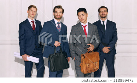 Businessmen hold important work materials, posing in formal attire and expressing readiness for business decisions against white background. 118899472