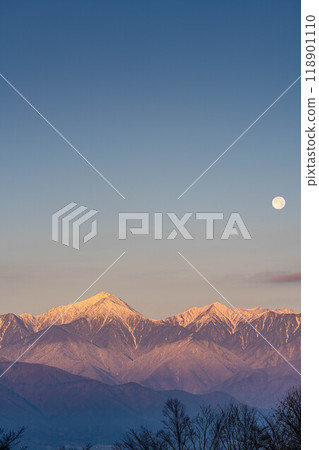 [Moon material] Northern Alps and full moon at sunrise in winter [Nagano Prefecture] 118901110