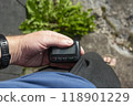 Hand tooks out retro pager with a display from his pocket on the street 118901229