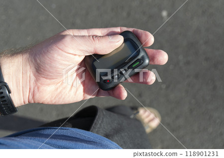 Man pulled out pager with a display from his pocket on the street 118901231