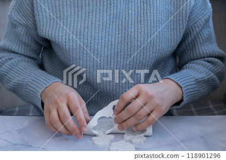 Creator is using white air dry clay for making decor to Christmas tree holiday. Creating hobby recreation activity that involves fingers. DIY crafting 118901296