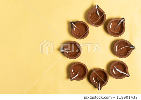 Happy Diwali - Hindu traditional clay diya arrangement for Diwali festival of lights celebration on yellow background. 118901432