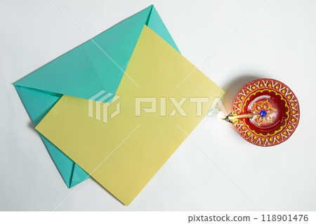 Burning clay diya lamp with greeting card on white background to wish Diwali festival celebration. Burning clay diya lamp with greeting card on white background to wish Diwali festival celebration. 118901476