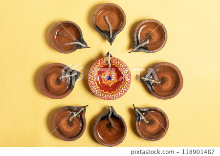 Happy Diwali - Traditional clay lamp lights on yellow background during celebration of Hindu festival Diwali. 118901487