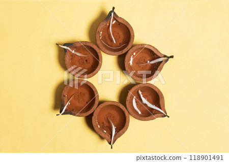 Hindu traditional clay diya arrangement for Diwali celebration on yellow background with copy space for text. 118901491