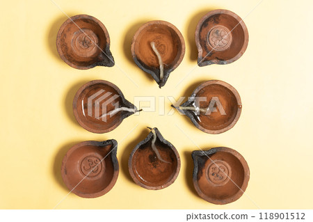 Arrangement of traditional clay oil lamps for Diwali festival celebration on yellow background. Arrangement of traditional clay oil lamps for Diwali festival celebration on yellow background. 118901512