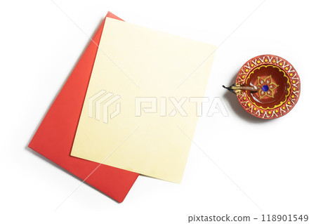 Red envelope with blank yellow paper sheets and clay oil lamps on white background to wish Diwali festival Red envelope with blank yellow paper sheets and clay oil lamps on white background to wish Diwali festival 118901549