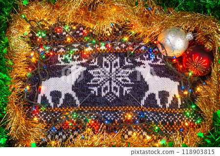 Festive knitted fabric with reindeer pattern and Christmas decorations 118903815