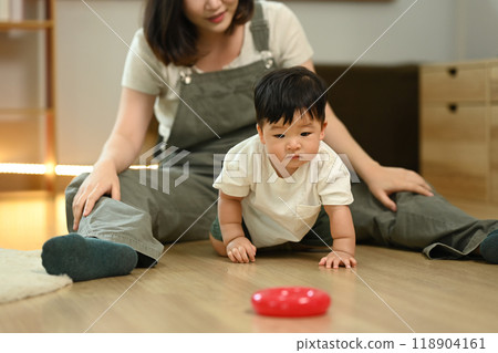 Adorable baby boy crawling on the floor, explore their surroundings Child development and nurturing care concept Adorable baby boy crawling on the floor, explore their surroundings Child development and nurturing care concept 118904161