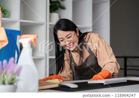 Dedicated Housekeeper Performing Thorough Office Desk Cleaning Dedicated Housekeeper Performing Thorough Office Desk Cleaning 118904247