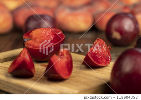 red ripe plum during cooking and slicing red ripe plum during cooking and slicing 118904358