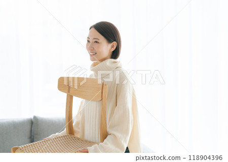 一個女人在客廳搬椅子 118904396