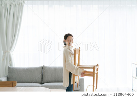 Woman moving a chair in the living room - Stock Photo [118904400] - PIXTA