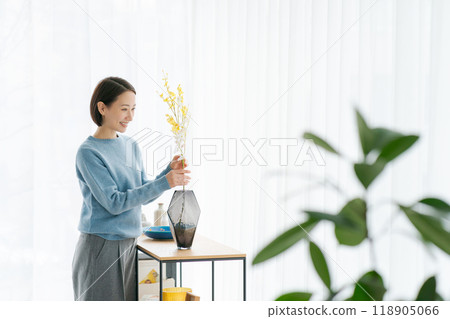 一位 30 多歲的女士用鮮花裝飾她的房間 118905066