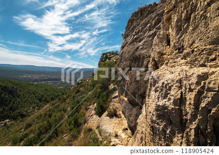 landscape of Rocky Cliffside Path Overlooking Lush Green Valley with Expansive Sky View landscape of Rocky Cliffside Path Overlooking Lush Green Valley with Expansive Sky View 118905424