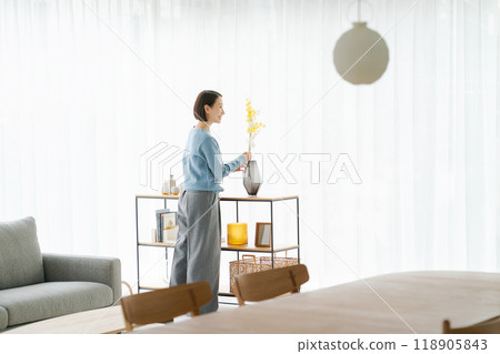 一位 30 多歲的女士用鮮花裝飾她的房間 118905843