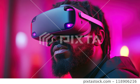 Immersed in vibrant world, man wearing VR glasses experiences thrill of virtual reality against striking pink background. His focused expression captures excitement of technology 118906216