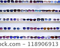Organized rows of sunglasses, vibrant lenses in different styles, white shelves displaying fashion accessories, retail presentation enhancing shopping ambiance, front view. 118906913