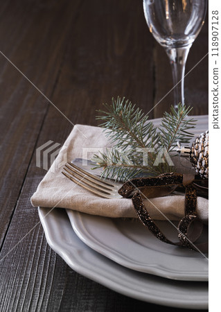 Christmas table setting with silverware and dark natural evergreen decor on black table. Top view. Holiday Centerpieces. Christmas table setting with silverware and dark natural evergreen decor on black table. Top view. Holiday Centerpieces. 118907128
