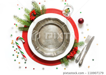 Christmas table setting with vintage dishware, silverware and red decorations on white background. Top view. 118907179