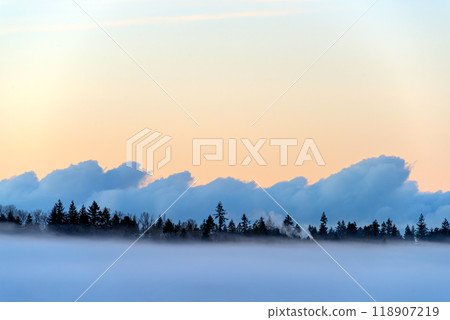 Foggy winter evening on puffy clouds and clear sky background 118907219