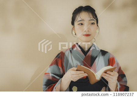 A woman in a kimono reading 118907237