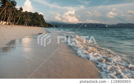 Calm evening on a sandy beach with boats sailing in the distance. Boracay, Philippines. Calm evening on a sandy beach with boats sailing in the distance. Boracay, Philippines. 118908903