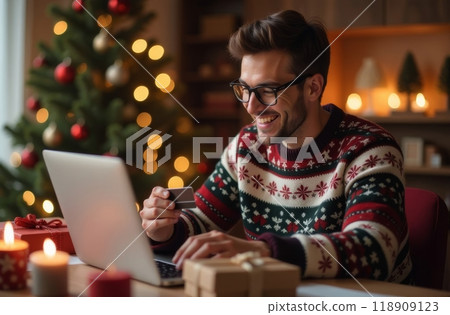 A young man in a festive sweater shops online while surrounded by Christmas decorations 118909123