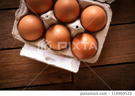 Egg box on a rustic wooden board 118909528