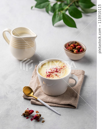 Golden milk latte with turmeric and rose petals. Trendy Indian drink Moon milk with natural spices. Golden milk latte with turmeric and rose petals. Trendy Indian drink Moon milk with natural spices. 118910115