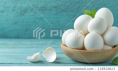Fresh white eggs stacked in a wooden bowl on a blue table 118910621