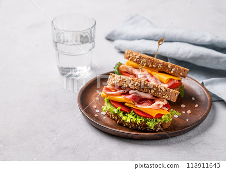 Two toast club sandwiches made of grain bread with cheddar cheese and bacon stuffed with tomatoes Two toast club sandwiches made of grain bread with cheddar cheese and bacon stuffed with tomatoes 118911643