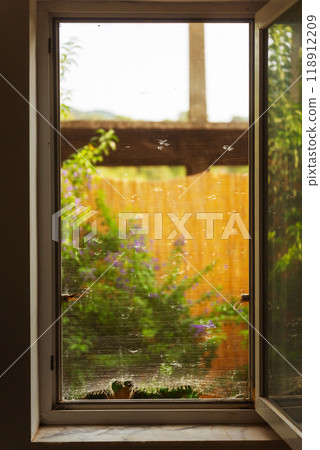 Old mosquito net with holes on the window 118912209