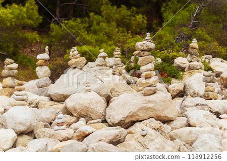 Zen stones neatly arranged stack of rocks surrounded by trees in the background Zen stones neatly arranged stack of rocks surrounded by trees in the background 118912256