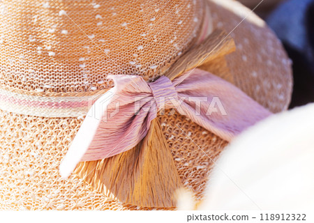 a detailed closeup image of a hat adorned with a pink bow 118912322
