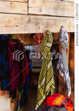 A collection of various oriental arafat scarves hanging on wooden wall 118912339
