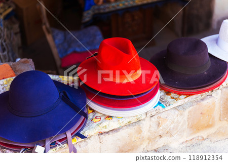 A collection of various hats is currently resting on a stone wall A collection of various hats is currently resting on a stone wall 118912354