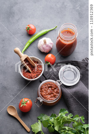 Homemade tomato sauce for pizza or pasta in a jar on a gray background Homemade tomato sauce for pizza or pasta in a jar on a gray background 118912369