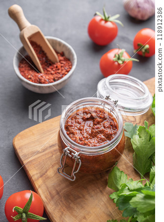Homemade tomato sauce for pizza or pasta in a jar on a gray background with fresh vegetables 118912386