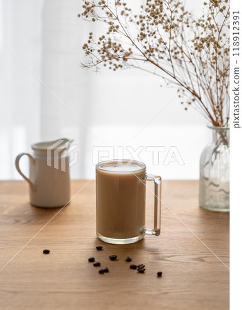 A cup of coffee with milk on a wooden table with coffee beans against the background A cup of coffee with milk on a wooden table with coffee beans against the background 118912391