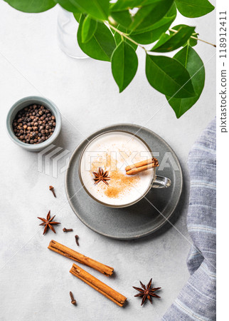 Traditional Indian masala chai latte in a glass cup. Hot drink with milk, spices and herbs  118912411