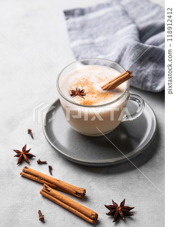 Traditional Indian masala chai latte in a glass cup. Hot drink with milk, spices and herbs Traditional Indian masala chai latte in a glass cup. Hot drink with milk, spices and herbs 118912412