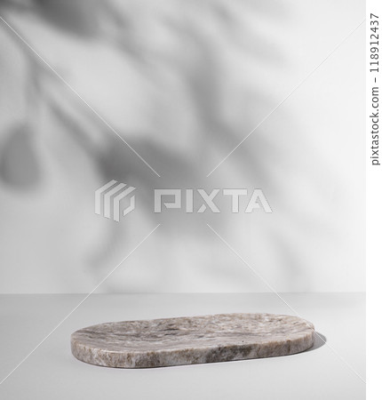 Marble oval board with shadow of plants on a light background for product demonstration. Marble oval board with shadow of plants on a light background for product demonstration. 118912437
