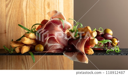 Prosciutto with bread sticks, olives, and rosemary. 118912487