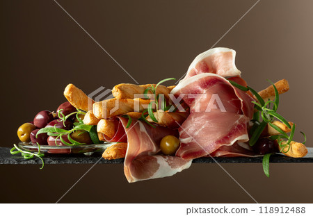 Prosciutto with bread sticks, olives, and rosemary. Prosciutto with bread sticks, olives, and rosemary. 118912488