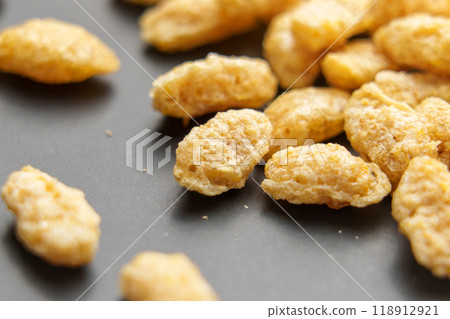 Macro shot of whole grains of processed oat corn flakes on a neutral grey ceramic Macro shot of whole grains of processed oat corn flakes on a neutral grey ceramic 118912921