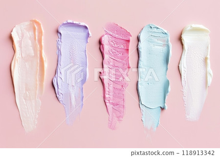 A set of five skincare samples, each with a unique texture and color, applied in vertical stripes. The smooth and rich consistencies showcase a variety of skincare product types 118913342