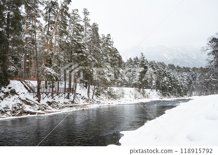 A beautiful landscape with a mountain river, snow and forest in Arkhyz, on a cloudy winter day.  118915792