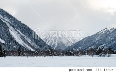 Beautiful landscape in Arkhyz with mountains, snow and forest on a cloudy winter day. Beautiful landscape in Arkhyz with mountains, snow and forest on a cloudy winter day. 118915806