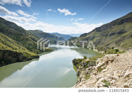Beautiful landscape with mountains and a river on a sunny summer day with clouds. 118915843